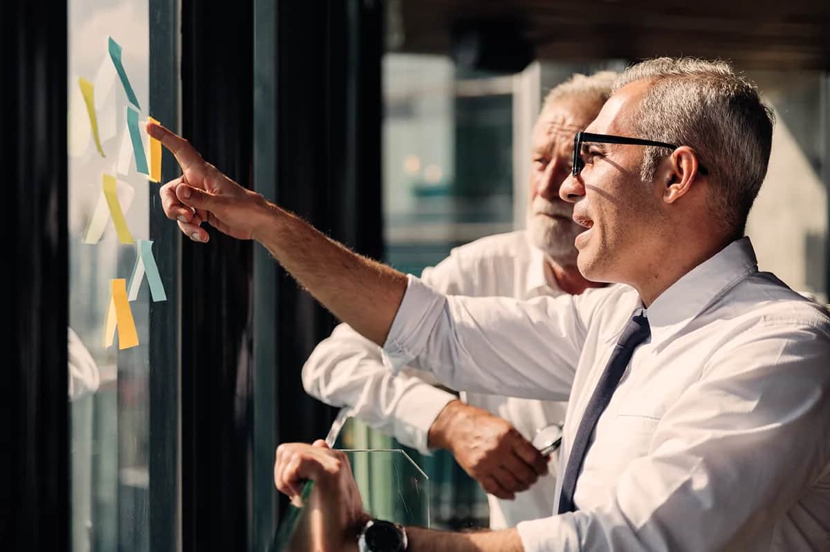 Leaders reviewing portfolio and systems strategy on a window